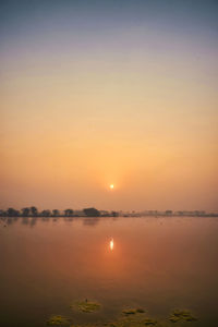 Scenic view of lake against sky during sunset