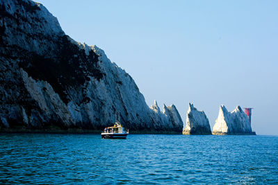 Sailboats sailing in sea against clear sky