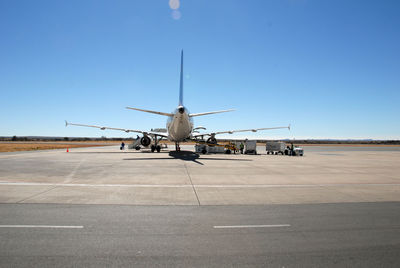 Airplane on airport runway against clear sky