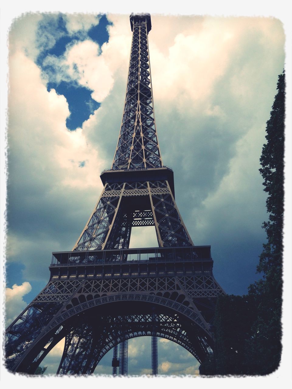 eiffel tower, architecture, built structure, transfer print, sky, culture, international landmark, famous place, low angle view, tower, metal, travel destinations, capital cities, cloud - sky, tourism, auto post production filter, tall - high, history, travel, cloudy