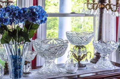 Close-up of flower vase on table against window at home