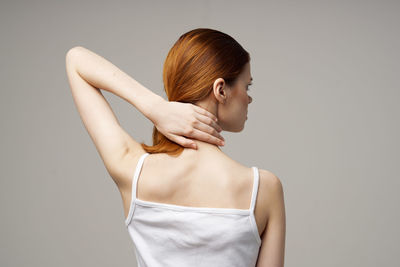 Midsection of woman standing against gray background