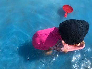 High angle view of girl playing with toys in swimming pool