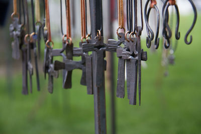 Close-up of metallic crosses hanging outdoors
