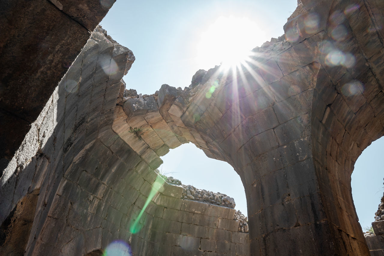 architecture, lens flare, history, sky, the past, travel destinations, nature, sunlight, sunbeam, travel, sun, arch, built structure, low angle view, old ruin, ancient, city, rock, outdoors, day, tourism, temple, landmark, sunny, back lit