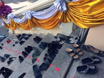 High angle view of shoes and sandals on steps at temple