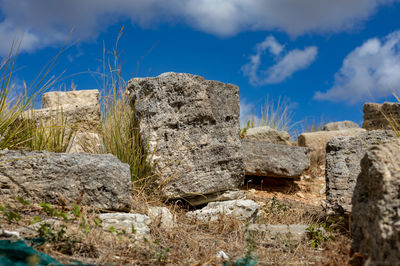 Rocks on field against sky