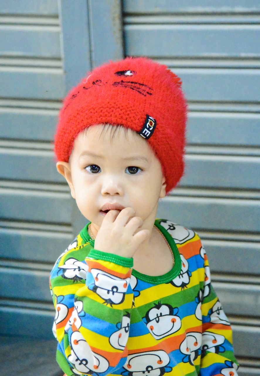 real people, child, one person, childhood, innocence, portrait, cute, baby, clothing, babyhood, lifestyles, red, young, front view, hat, day, toddler, looking away, outdoors, warm clothing