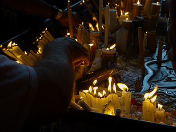 Statue of illuminated candles in temple outside building