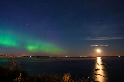 Scenic view of lake against sky at night