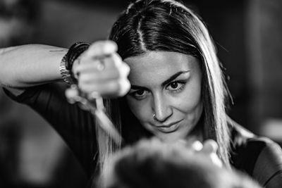 Close-up of woman cutting man hair at shop