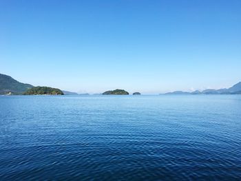 Scenic view of lake against clear blue sky