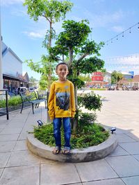 Full length of man standing against plant outdoors