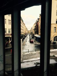 Cars on city street against sky