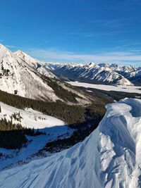 Scenic view of snowcapped mountains against blue sky