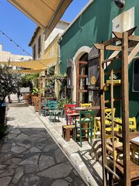 Chairs and tables on street amidst buildings in city