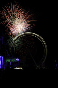 Low angle view of firework display at night