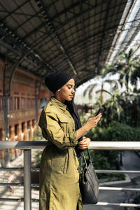 Portrait of young woman standing in city