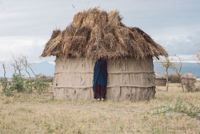 View of masai woman under cottage roof