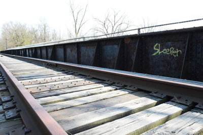 Train by railroad tracks against sky