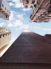 Low angle view of buildings against cloudy sky