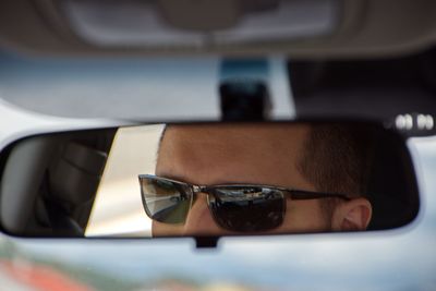 Close-up of man wearing sunglasses in car