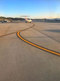 Airplane on runway against blue sky