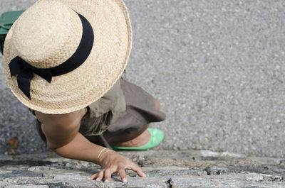 High angle view of women wearing straw hat standing by wall