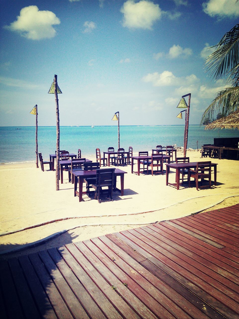 sea, beach, horizon over water, sand, water, sky, shore, tranquil scene, tranquility, scenics, absence, sunlight, nature, chair, beauty in nature, vacations, parasol, empty, lounge chair, incidental people