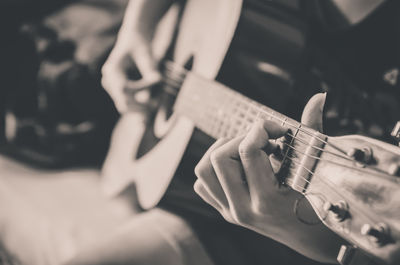 Midsection of woman playing guitar