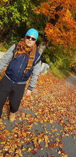 Portrait of woman with autumn leaves on tree