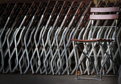 Stack of empty chairs against building