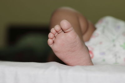 Low section of baby feet on bed