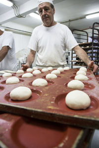 Doughs in hamburger bread molds before baking in a bakery