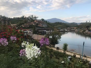 Scenic view of river by buildings against sky