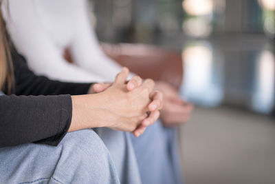 Midsection of couple holding hands