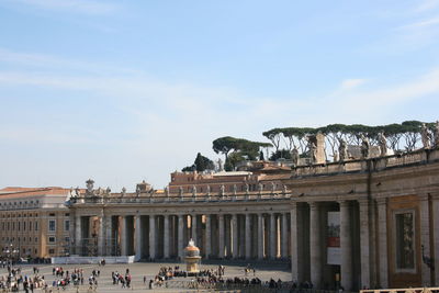 Group of people in front of historical building against sky