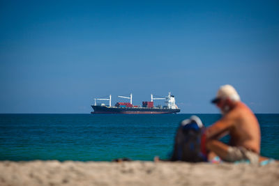 Nautical vessel on beach against clear sky