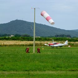 Umbrellas flying over field against sky