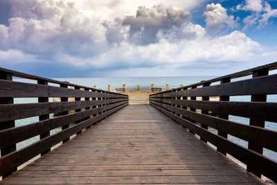 View of pier on sea against cloudy sky