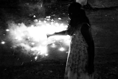 Woman standing in water at night