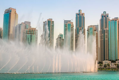 Panoramic view of sea and cityscape against clear sky