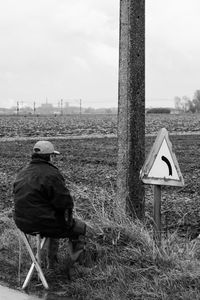 Rear view of man sitting on field