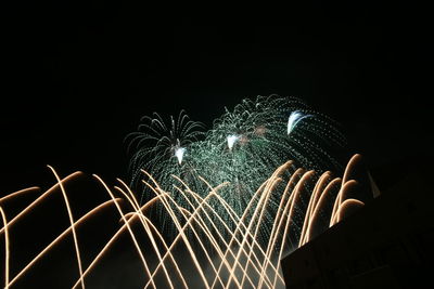 Low angle view of firework display against sky at night