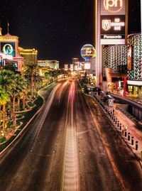 Illuminated city street and buildings at night