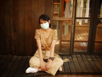 Full length of woman sitting on wooden floor