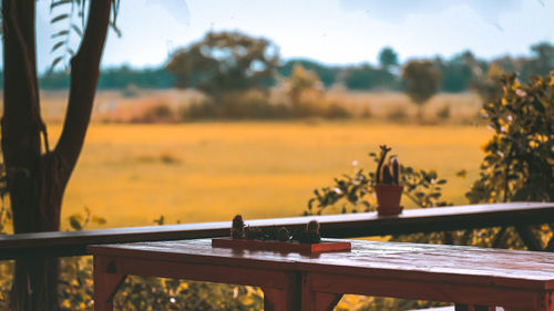 Close-up of table by window against sky