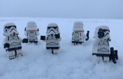 People on snow covered landscape against sky