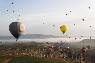 Hot air balloons flying over landscape