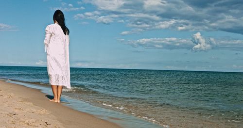 Rear view of woman looking at sea against sky